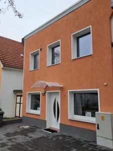 ceglany dom z białymi drzwiami i oknami w obiekcie Gästehaus-Ferienwohnung-Appartement mit Terrasse - Nähe Kliniken/ Herzzentrum w mieście Bad Oeynhausen