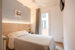 1 dormitorio con cama y ventana en Eurohotel, en Mahón