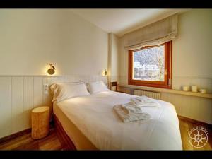 a bedroom with a large white bed with a window at MALADETA de Alma de Nieve in Baqueira-Beret