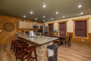 ガトリンバーグにあるNo Name Cabin chaletのキッチン(大きなカウンター、椅子、テーブル付)