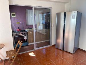 a kitchen with a stainless steel refrigerator and a chair at HOSTAL SAIRI in San Pedro de Atacama