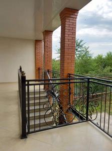 a balcony with a black railing and a staircase at Family hotel leni in Kvareli