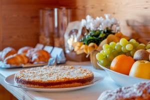 una mesa con platos de pan y fruta. en Garnì Vecchio Comune, en Flavon