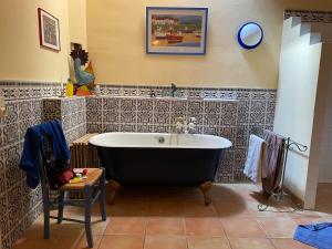 eine Badewanne im Bad mit einer Kachelwand in der Unterkunft Große Ferienwohnung am Canal du MIDI mit Dachterrrasse in Homps