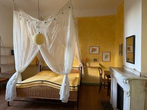 1 dormitorio con cama con dosel y mesa en Große Ferienwohnung am Canal du MIDI mit Dachterrrasse en Homps