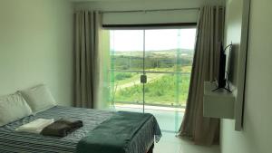 a bedroom with a bed and a large window at FLAT VILLA MONTE CASTELO in Bezerros +19 photos