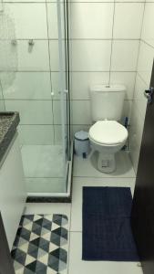 uma casa de banho com um WC e uma cabina de duche em vidro. em FLAT VILLA MONTE CASTELO em Bezerros