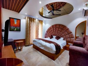罗塔克Hotel Joylife- Chottu Ram Chowk Rohtak Haryana的配有一张大床和一张沙发的酒店房间
