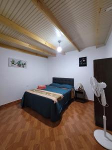 a bedroom with a bed and a fan in a room at HOSTAL SAIRI in San Pedro de Atacama