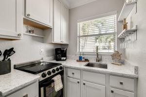 a kitchen with white cabinets and a stove and a sink at Enjoy the Pool while being Steps from Beach and Restaurants! - Coconut Villa's Suite 6 in St. Pete Beach