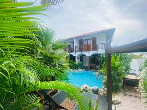 a house with a swimming pool and palm trees at NEW HOUSE TROPIC PARADISE with Pool in Willemstad