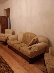 a living room with a couch with a pillow on it at Family hotel leni in Kvareli