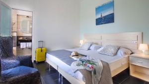 a hotel room with a bed and a yellow suitcase at Hotel Spiaggia Marconi in Rimini