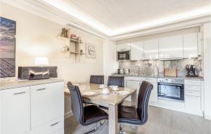 a kitchen with white cabinets and a wooden table and chairs at Princess in Binz