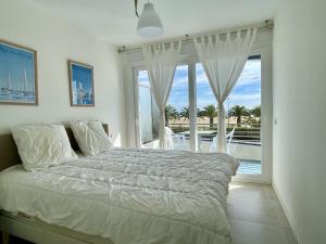een slaapkamer met een bed en een groot raam bij Catalonia 1-7 in L'Estartit