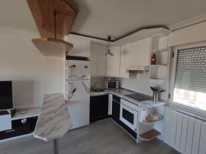 een keuken met een witte koelkast en een fornuis bij ATICO Romo in Santa Marta de Tormes