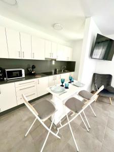 a kitchen with a white table and chairs in a kitchen at Luxury Beach Apartments Diama in Playa Honda