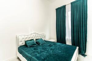 Un dormitorio con una cama con sábanas verdes y una ventana en Oasis, en Chişinău