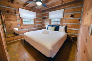 1 dormitorio con 1 cama en una cabaña de madera en The Mayfly Cabin - Fightingtown creek, fly fishing, mountain view, fire pit, pet friendly getaway! en McCaysville