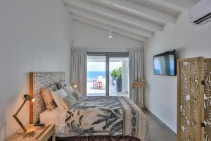 1 dormitorio con 1 cama y vistas al océano en 5 BR Luxurious Beachfront Villa with utmost privacy, en Les Terres Basses