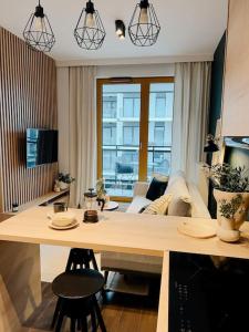 - un salon avec une table et un canapé dans l'établissement Przytulny Apartament Greenwall, à Cracovie