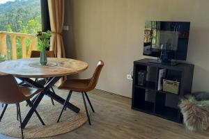 a dining room with a table and chairs and a window at Cabin Quinta Pomar Do Pontido in Cabeceiras de Basto +16 photos