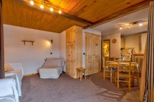 1 dormitorio con 1 cama y 1 mesa y 1 dormitorio con comedor en Le Bois Joly, en La Giettaz
