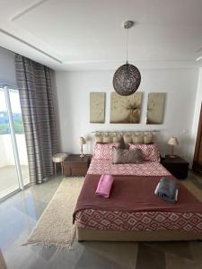 1 dormitorio con cama grande y ventana grande en Apparemment de luxe en Hammamet