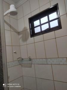 y baño con ducha y ventana. en Casa mobiliada, en Campo Grande
