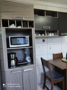 cocina con mesa y microondas en Casa mobiliada, en Campo Grande