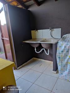 une salle de bain avec un lavabo dans le coin d'une pièce dans l'établissement Casa mobiliada, à Campo Grande
