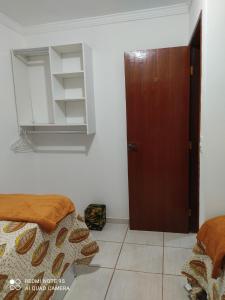 Habitación con 2 camas y puerta de madera en Casa mobiliada, en Campo Grande