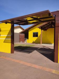 un edificio amarillo con toldo en un estacionamiento en Casa mobiliada, en Campo Grande