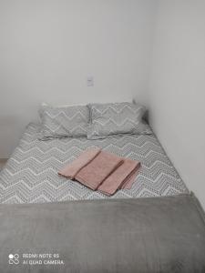 Una cama con dos toallas encima. en Casa mobiliada, en Campo Grande