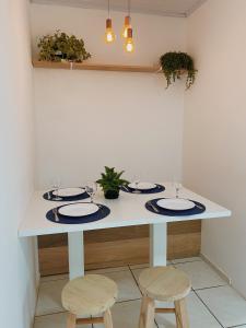 Una mesa blanca con dos sillas y dos platos. en Casa Rio Tavares - 3min da praia - Pico da Cruz, en Florianópolis