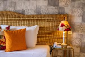 a bed with a lamp on a night stand next to it at Bahiamarela Boutique Hotel & SPA in Búzios