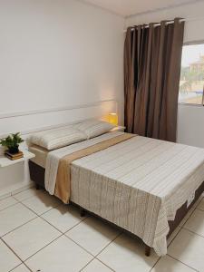 1 dormitorio con 1 cama grande y ventana en Casa Rio Tavares - 3min da praia - Pico da Cruz, en Florianópolis