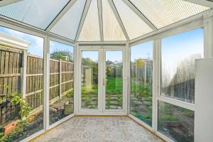 an empty conservatory with large windows and a glass roof at 3bed Cozy House Parking Wifi in Welling