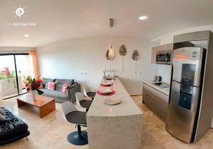 a kitchen and living room with a refrigerator and a table at Suites calle 38 in Playa del Carmen