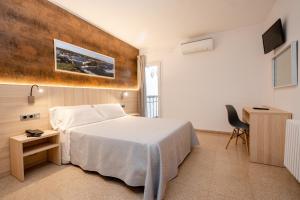 a bedroom with a bed and a desk and a television at Eurohotel in Mahón