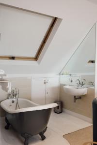 a bathroom with a bath tub and a sink at Beautiful 4 Bed Beach House in Pevensey
