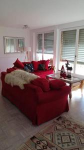 a living room with a red couch and a table at Lovely 3 Bedroom Apt. in Maloja