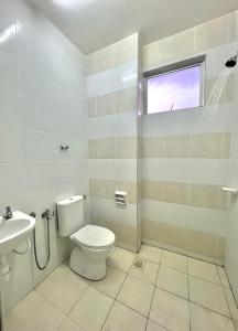 a bathroom with a toilet and a sink at SuaTamu Homestay One Aircond in Kamunting