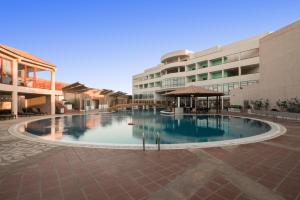 a large swimming pool in front of a building at Alreem Village Hotel in Al Jubail