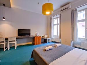 a bedroom with a bed and a desk with a television at Apartments Cilindar in Zagreb