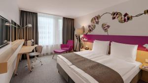a hotel room with a large bed and a desk at Holiday Inn Frankfurt - Alte Oper, an IHG Hotel in Frankfurt