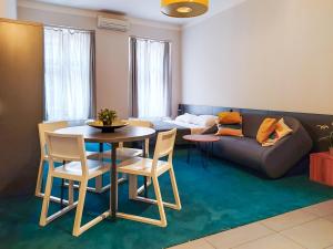 a living room with a couch and a table and chairs at Apartments Cilindar in Zagreb