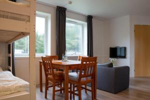 a dining room with a table and chairs and a bed at Vollvaagen Apartments Smøla, boat included in Smøla