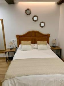 ein Schlafzimmer mit einem großen weißen Bett mit zwei Tischen in der Unterkunft Bonito apartamento en el centro de Pontedeume. in Puentedeume