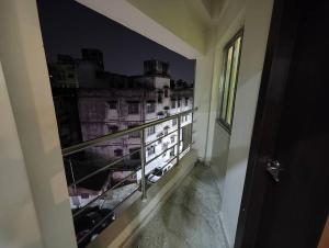 um quarto com uma varanda com vista para a cidade em Lavish 2BHK, 10 mins from AMRI Hospital Dhakuria em Calcutá